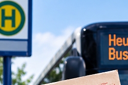 Ein Streik Schild wird vor einem Bus in die Höhe gehalten