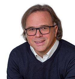 Porträtbild von Carsten Gabbert. Er trägt Brille und einen blauen Pullover. 