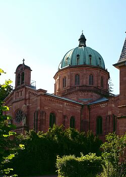 Auf dem Foto ist ein Turm in Farben der Backsteine zu sehen, welcher ein blaues Dach hat 