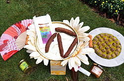 Diverse Produkte auf denen Chrysanthemen abgebildet oder enthalten sind. Chrysanthemen-Salami, Chrysanthemen-Trüffel, Chrysanthemen-Pesto, Fächer.