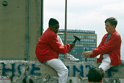 Jugendliche mit Hammer und Meißel an der Mauer
