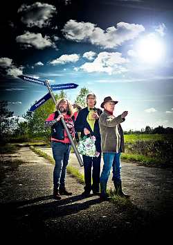 Drei Männer, einer mit einem Wegweiserschild über der Schulter mit drei Aufschriften "Schuldenberg", "Panama" und "Finanzministerium" stehen ratlos in der Landschaft rum. Jeder zeigt in eine andere Richtung.