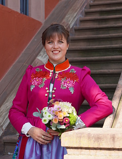 Valerie Hübner im farbenfrohen Kleid der Chrysanthemenkönigin steht auf der Treppe am Alten Rathaus in Lahr.