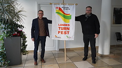(von links nach rechts): Lahrs Oberbürgermeister Markus Ibert und Erster Bürgermeister Guido Schöneboom halten in der Mitte die Landesturnfestfahne