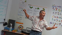 Alexander Müller steht gestikulierend am Lehrerpult. 