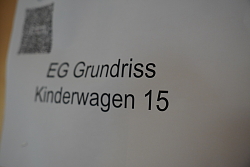 Weißes Schild mit der Aufschrift „EG Grundriss Kinderwagen 15“.