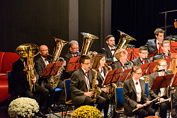 Die Stadtkapelle Lahr spielt im Parktheater. Das Bild zeigt die linke Seite des Orchesters mit Flöten, Saxofonen und Tuben. Die Musiker sind elegant mit anthrazitfarbenem Jacket, weißem Hemd und roter Fliege gekleidet. 