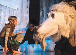 Der Junge Bastian kniet vor dem Drachen Fuchur.