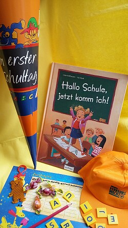 Auf dem Bild ist auf der linken Seite eine Schultüte zu sehen und auf der rechten Seite ein Buch mit dem Titel: &#34;Hallo Schule, jetzt komme ich&#34;. 