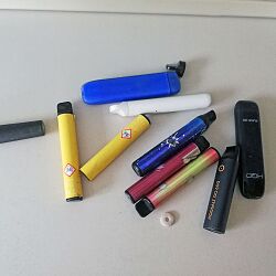 Mehre Einweg-E-Zigaretten verschiedener Art, die der BGL in Grünflächen gefunden hat, liegen auf einem Tisch