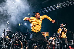 Ein Sänger springt auf einer Bühne.