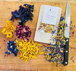 Das Bild zeigt verschiedene getrocknete essbare Blüten, einmal offen und einmal in der Verpackung