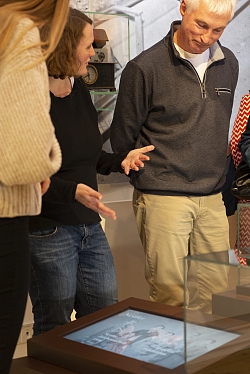 Das Foto zeigt drei Personen, die auf einen Bildschirm schauen, der im Boden eingelassen ist.