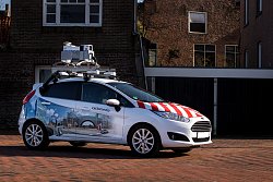 Auf dem Bild ist ein Fahrzeug der Firma cyclomedia zu sehen, das zur Kamerabefahrung und zum Laserscanning eingesetzt wird. Das Fahrzeug hat auf dem Dach die dafür entsprechende technische Ausrüstung. Seitlich ist eine Stadtansicht auf das Fahrzeug aufgebracht und auf der Kühlerhaube sind deutlich rote Warnstreifen zu sehen.