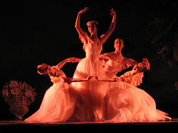 Vier Ballett-Tänzerinnen tragen weiße Ballkleider und tanzen. 