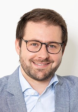 Philipp Fischer lacht frontal in die Kamera.