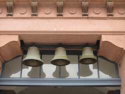 Drei Glocken, die über dem Eingang der ehemaligen Luisenschule hängen.