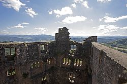 Wunderschönes Bild von der Spitze des Hohengeroldseck in die Ebene. Im Vordergrund sieht man die Innenseiten der Burgruine, im Hintergrund Wiesen, Wälder und Hügel.