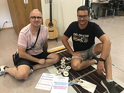 Auf dem Bild sind zwei Männer im Vordergrund zu sehen. Sie erarbeiten Methoden zur GrooveLAB Arbeit 