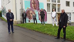 Erster Bürgermeister Guido Schöneboom, Sozialarbeiter Heiko Heimburger, Sprayerin Sarah Zepf, Sprayer Noah Tress, Sprayer David Rich und GEMIBAU-Vorstandsvorsitzender Dr. Fred Gresens (von links).