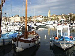 Das Bild zeigt Schiffe im Hafen von Sanary sur Mer, dahinter Gebäude der Stadt, Foto Manfred Hammes