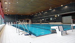 Schwimmerbecken mit Startblock und Einstieg im Vordergrund