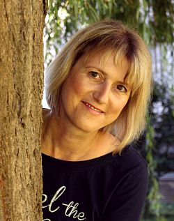 Lesung in der Mediathek Lahr mit der Autorin Heidrun Hurst.
Heidrun Hurst schaut hinter einem Baumstamm hervor. Sie trägt einen schwarzen Pullover mit weißer Aufschrift. Heidrun Hust lächelt freundlich. Sie hat braune Augen und ihre blonden glatten Haare trägt sie kinnlang.