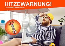 A man is sitting in an apartment on a lounge chair, with a fan on his lap, wearing sunglasses and a sun hat, and groaning from the heat.
