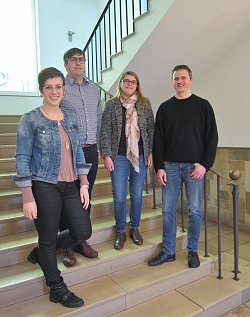 Das Foto zeigt zwei Frauen und zwei Männer, die auf einer Treppe stehen