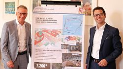 Oberbürgermeister Markus Ibert und Frank Peter Rottenecker, Vorstandsvorsitzender der Volksbank Lahr (von links) stehen neben einem Plakat, das Perspektiven für Volkshochschule und Mediathek auf dem Post-Areal aufzeigt