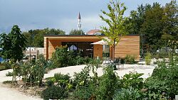 Kleingarten mit Gartenhaus vor einer Moschee