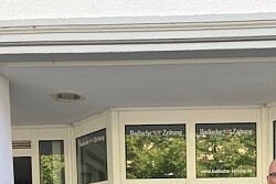 Gamze und Thomas stehen neben einem Plakat, worauf Steetwork Lahr steht vor dem neuen Jugendraum. 