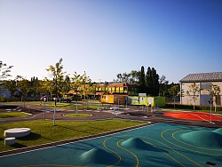 Blick auf den Übungsplatz der Jugendverkehrsschule Lahr. Zu sehen sind eine Parkour, ein Kreisverkehr und andere Übungsstrecken für junge Radfahrer. Dazwischen wurde Rasen angelegt, die einzelnen Elemente sind bunt und kindgerecht gestaltet.