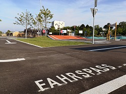 Blick auf den Übungsplatz der Jugendverkehrsschule Lahr. Zu sehen sind verschiedene Straßen und Übungsstrecken für junge Radfahrer. Im Vordergrund ist auf dem Asphalt der Schriftzug 