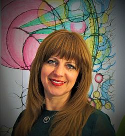 Auf dem Bild ist die Vortragende Julia Dold abgelichtet. Sie lächelt freundlich in die Kamera und trägt lange durchgestufte braune Haare und roten Lippenstift. 