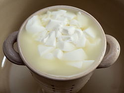 Experimentelle Herstellung von Käse mit Kälberlab in einer alten Käseform