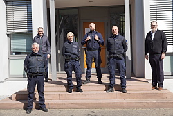 Das Foto zeigt mehrere Personen, die auf einer Treppe stehen. Ein Teil der Personen trägt Uniform. 