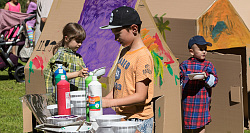 Kinder malen mit Farbe Kartons an