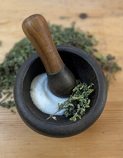 Man sieht eine dunkle Schale in der Salz gestampft wurde.