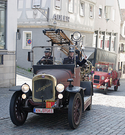 Eine Kraftspritze mit zwei Feuerwehrmännern 