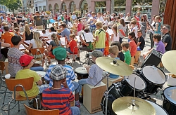 Das Bild zeigt zahlreiche Musikschüler, die ein Konzert auf dem Schlossplatz geben.