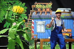 Das Bild zeigt eine Szene aus dem Löwenzahnprogramm mit den kostümierten Darstellern und im Hintergrund die Bauwagen-Kulisse.