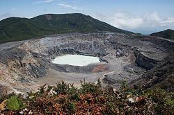 Das Bild zeigt den Krater des Vulkans Poas bei Alajuela. am Boden ist ein zugefrorener See zu erkennen.