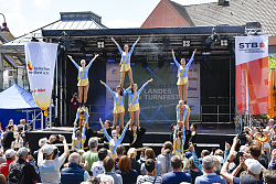 Das Foto wurde bei der Abschlussveranstaltung auf dem Marktplatz aufgenommen und zeigt eine Sportgruppe bei einer Aufführung.