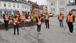 Gruppenbild der städtischen Auszubildenden mit den Kollegen der Stabsstelle Umwelt auf dem Rathausplatz. Alle tragen organge Warnwesten.