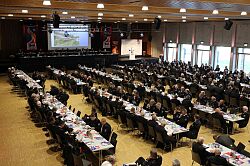 Feuerwehrangehörige an langen Tischen in der Mehrzweckhalle, von oben fotografiert