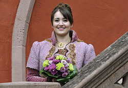 Lorena Harter präsentiert sich als Chrysanthemenkönigin im königlichen lila Gewand auf der Treppe des Alten Rathauses. 