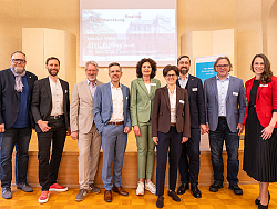 Gruppenbild der Verantwortlichen mit Guido Schöneboom (links) und Tilman Petters (dritter von links) im Pflugsaal vor einer Leinwand. Ganz rechts Regierungspräsident Carsten Gabbert. 