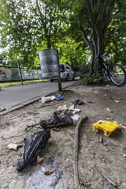 Müll auf dem Boden neben einem Mülleimer