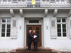 Auf dem Bild sind der Lahrer Oberbürgermeister Dr. Wolfgang G. Müller und Jörg Saalbach, Direktor des Europäischen Verbunds für Territoriale Zusammenarbeit (EVTZ), händeschüttelnd vor dem Lahrer Rathaus zu sehen.